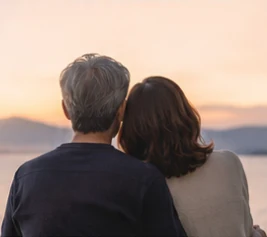 夕景を眺めながら寄り添う二人の後ろ姿